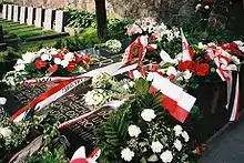 A grave with flowers and flags placed on top of it