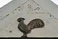 WRP (William Ralston-Patrick) and cockerel carving on the wall of the farm