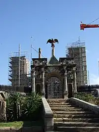 Crumbling partial walls of queen's palace supported by scaffolding