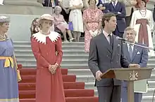Charles giving a speech at a podium in Edmonton, with Diana standing to his right