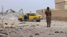 A SDF fighter stands in a destroyed area of Tabqa