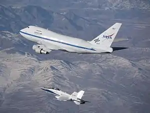 An F/A-18 mission support aircraft shadows SOFIA during a functional check flight.