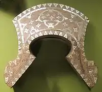 A saddle panel made of wood with shell inlay