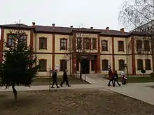 Two-story building with people walking past