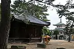 Large stones set in the ground in front of temple buildings.