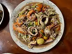 Lao papaya salad made with selected seafood, mixed with rice noodle (Sen Khao Poon in Lao) in addition to thin papaya strips