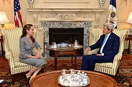 Angelina Jolie and Secretary Kerry sit in colonial easy chairs in the John Quincy Adams State Drawing Room