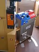 A fare box on a Shigaraki Kohgen Railway train. The blue section is a change machine, while the red section is where you pay. A boarding voucher dispenser is pictured to the left.