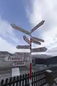 Sign post with distances to major cities around the world