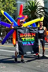 Two man holding a "Born This Way" sign