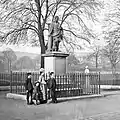 A late-19th-century view, illustrating the iron railing that formerly surrounded the statue, including at its original High Street location. The view into the South Inch is also unobstructed compared to the modern-day foliage that surrounds the statue