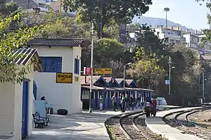 Station on a curve, with people waiting on the platform