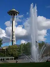 In this photograph, the "super shooters" installed by WET Design in 1995 are in operation and the water jets are reaching their peak height of approximately 120 feet (37 m). The ground level perspective creates an illusion the jet is nearly as tall as the Space Needle, shown in the background.