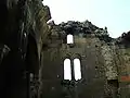 Remains of the vaulted ceiling resting above the southern aisle. Three windows may be also seen at the top of the west wall.