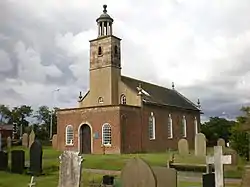 A Georgian style brick church seen from the southwest with a porch protruding in the foreground, a slim tower topped by a rotunda, and the body of the church extending beyond