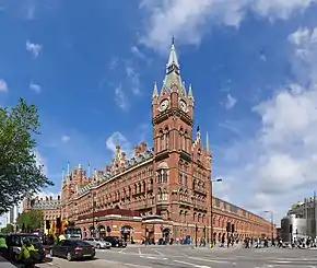 red stone building with tall clock tower in corner