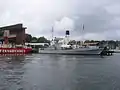 HSwMS Spica moored outside of the Vasa Museum in July 2005. The tall funnel belongs to SS Sankt Erik, moored on the other side of the jetty.