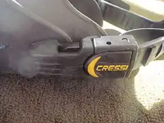 Swim fin strap attachment with swivelling plastic buckle and clip