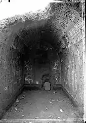 Interior of a fully decorated chapel with damaged decoration on the walls and ceiling