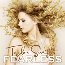 The cover artwork of Taylor Swift's 2008 album Fearless, showing Swift's side profile with blonde curly hair