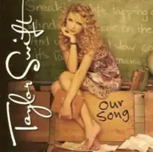 Cover artwork of "Our Song", depicting Swift sitting on a school desk