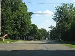 Main part of Tecumseh. Church and Topeka & Shawnee County Public Library bookmobile stop and book drop-off box to the left. United States Postal Service office to the right.
