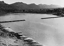 The 1,100 feet (340&nbsp;m) bridge over the Chindwin, in Burma, nearing completion in 1944. (The sections were constructed on a tributary and floated downstream on pontoons.)