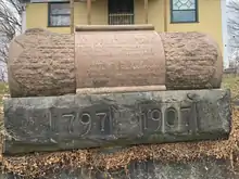 This image shows a monument in the shape of a scroll dedicated to the founder of Meadville, David Mead