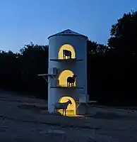 Goat tower at night with goats silhouetted on three levels