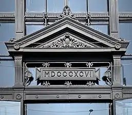 19th century Eclectic Classicist cartouches in and under a pediment of Hala Traian, Bucharest. The rectangular one is a revival of Ancient Roman ones, that had the exact same shape