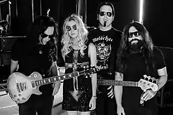 The Pretty Reckless in October 2014. From left to right: Ben Phillips, Taylor Momsen, Mark Damon, Jamie Perkins