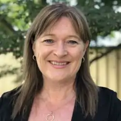The President of the Australian Progressive, Therese Faulkner, with a green background.