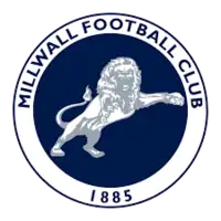 Millwall crest: a blue circle with a white border, in the centre is a white and grey lion, around the border are the words Millwall Football Club and the year 1885 in blue letters.