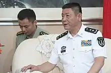 a man with a cropped haircut, wearing a white military uniform while looking leftwards (away from the camera)