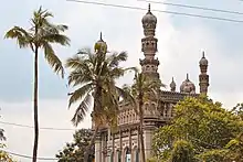 Medieval-era granite mosque surrounded by palm trees