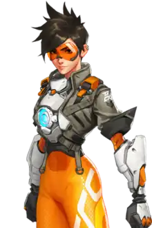 An illustration of a young, Caucasian woman with spiky, brown hair. She is wearing orange goggles over her eyes, a brown jacket, a blue lamp on her abdomen, brown gloves and orange leggings. There is some augmentation of the arms. She stands slightly angled, but facing the viewer with both of her hands clenched into fists and arms straight down to her sides.