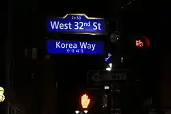 The Korea Way sign illuminated at night, with Hangul translation, in Koreatown