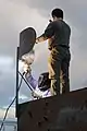Test services maintenance crewman weld the support brace of a fake radar dish on the top of a target shaped like a radar van at the Chocolate Mountain Aerial Gunnery Range (2010)