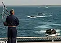 Capt. Rory Macdonald, Canadian Forces chaplain, plays the bagpipe to welcome aboard the amphibious assault vehicles and Marines.jpg