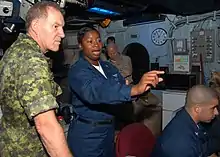Air Traffic Controller 1st Class Erica Banks explains the SPN 43 Radar System to General Walter Natynczyk, Canadian chief of Defense Staff, in the amphibious air traffic control center aboard the amphibious assault ship USS Bonhomme Richard (LHD 6)