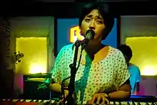Armi Milare singing and playing a keyboard