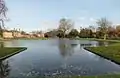 Upper pond looking towards the NPL. The Victorian Mews is on the left and Upper Lodge centre left. The tops of the alcoves are visible to either side of the gap where the Upper pond flows over the cascade