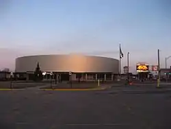 A brightly lit hockey arena, clad in metal panels.