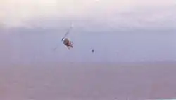 RVNAF pilot jumps from his Huey after dropping evacuees on USS Midway