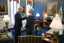Phot of Biden with his hand on Pence's shoulder, standing in Pence's office
