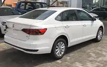  Rear-three-quarter view of a four-door car with a three-box body style whose luggage compartment is separate from the cockpit which is fitted with door mirrors.