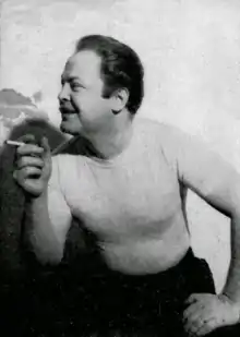 Virgil Finlay sitting, facing left, holding a cigarette