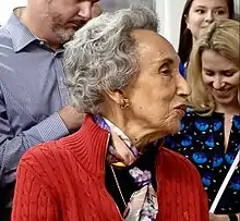 Profile view of Ali smiling at something off camera.