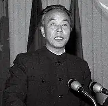Portrait of Wan Li speaking at a podium