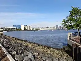 A photo looking north from Hoboken, NJ showing Weehawken, NJ on the left side and across the Hudson River Manhattan is viable.